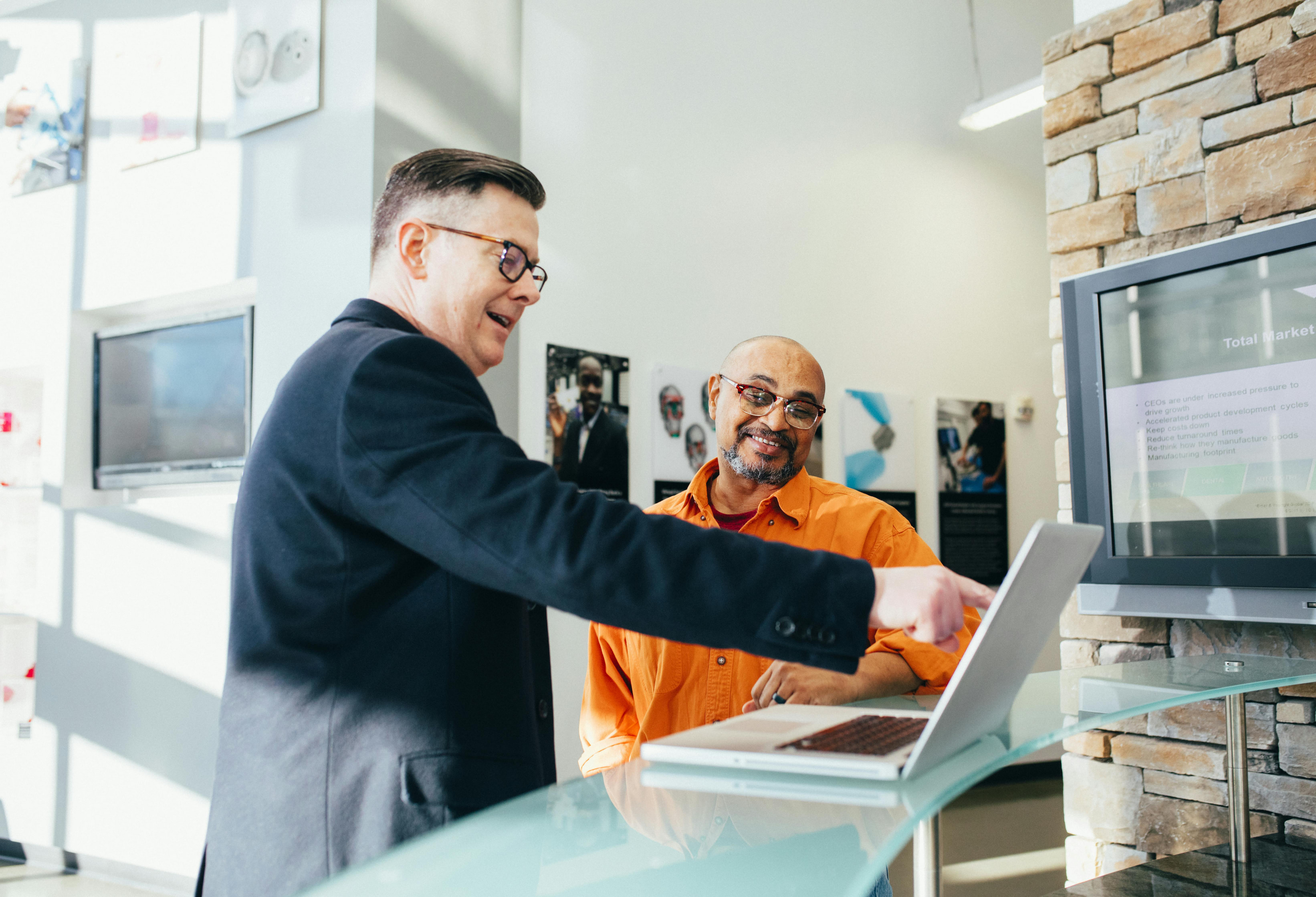 An accountant using a laptop to advise a business owner.