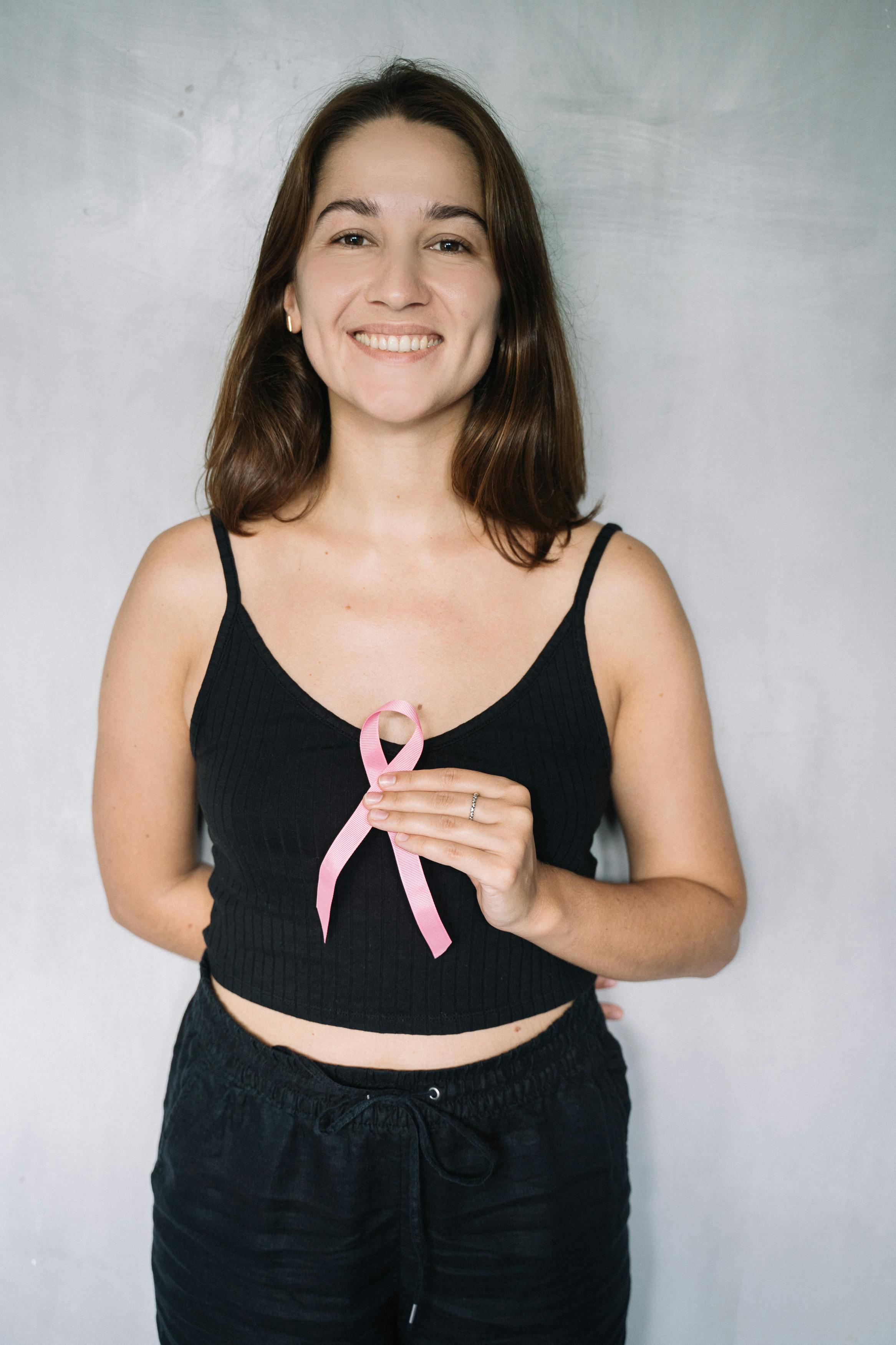 Young woman holding a pink breast cancer ribbon