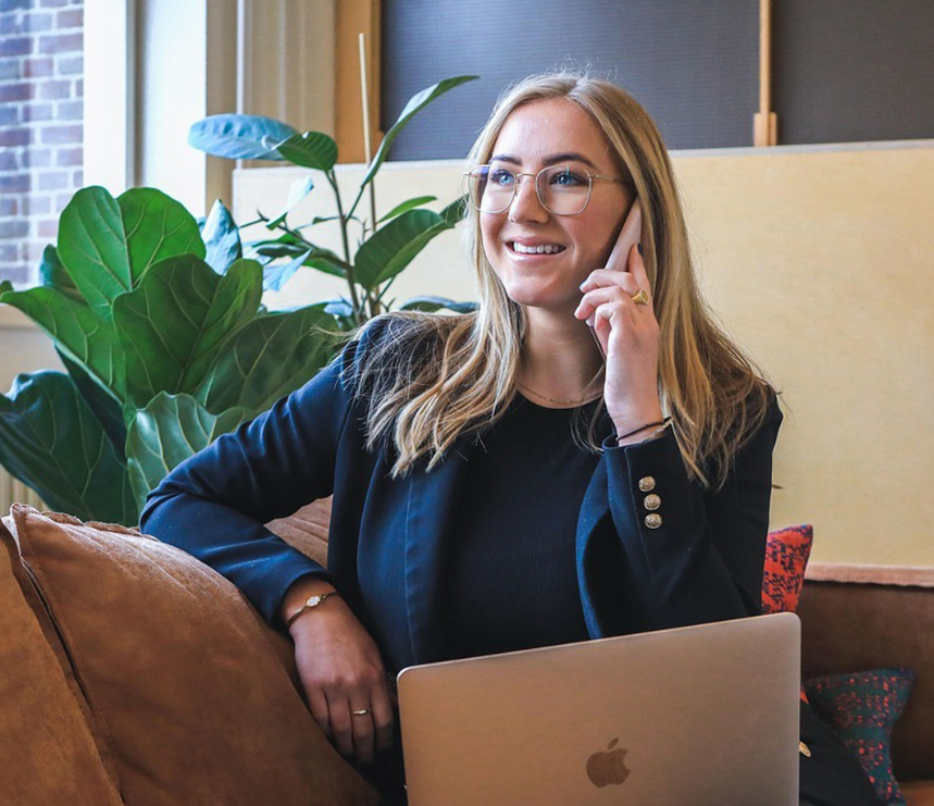 Step Ahead Accounting staff member on a phone call while taking notes on a laptop